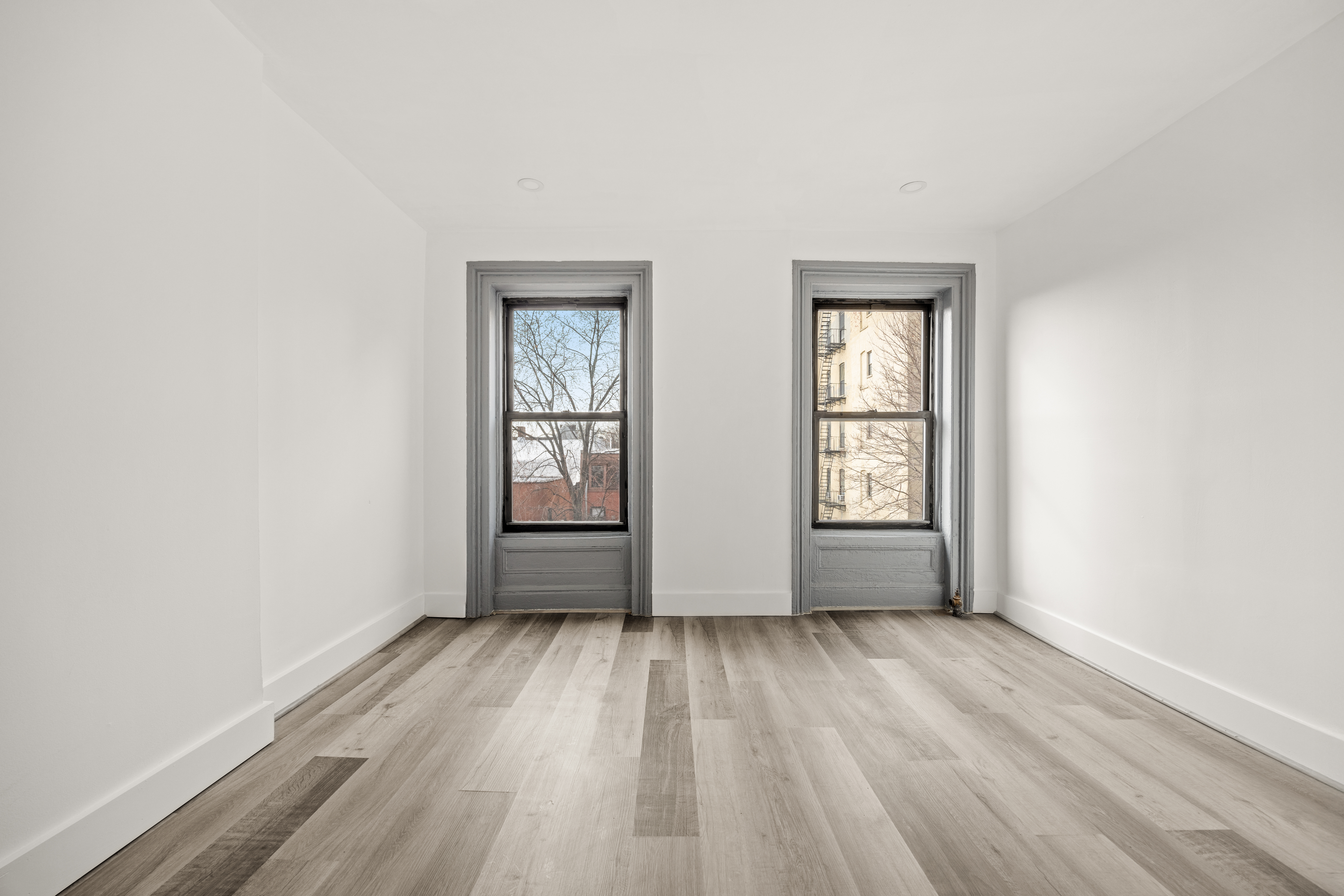 126 Quincy Street, Unit 3 Brooklyn, NY 11216 - Photo 4 of 11 an empty room with wooden floor and windows