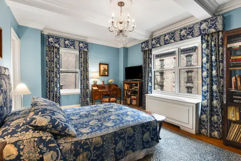 a bedroom with a bed and a flat tv screen on dresser