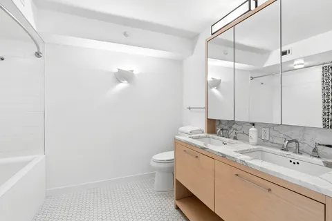 a bathroom with a sink a toilet and shower
