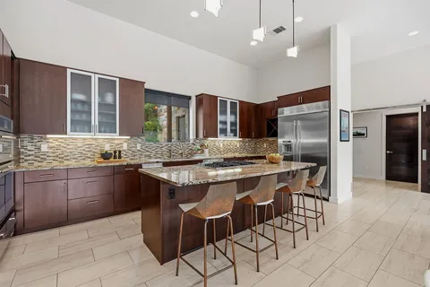a kitchen with stainless steel appliances granite countertop a sink stove and refrigerator