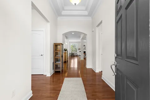 a hallway with wooden floor fireplace and living room