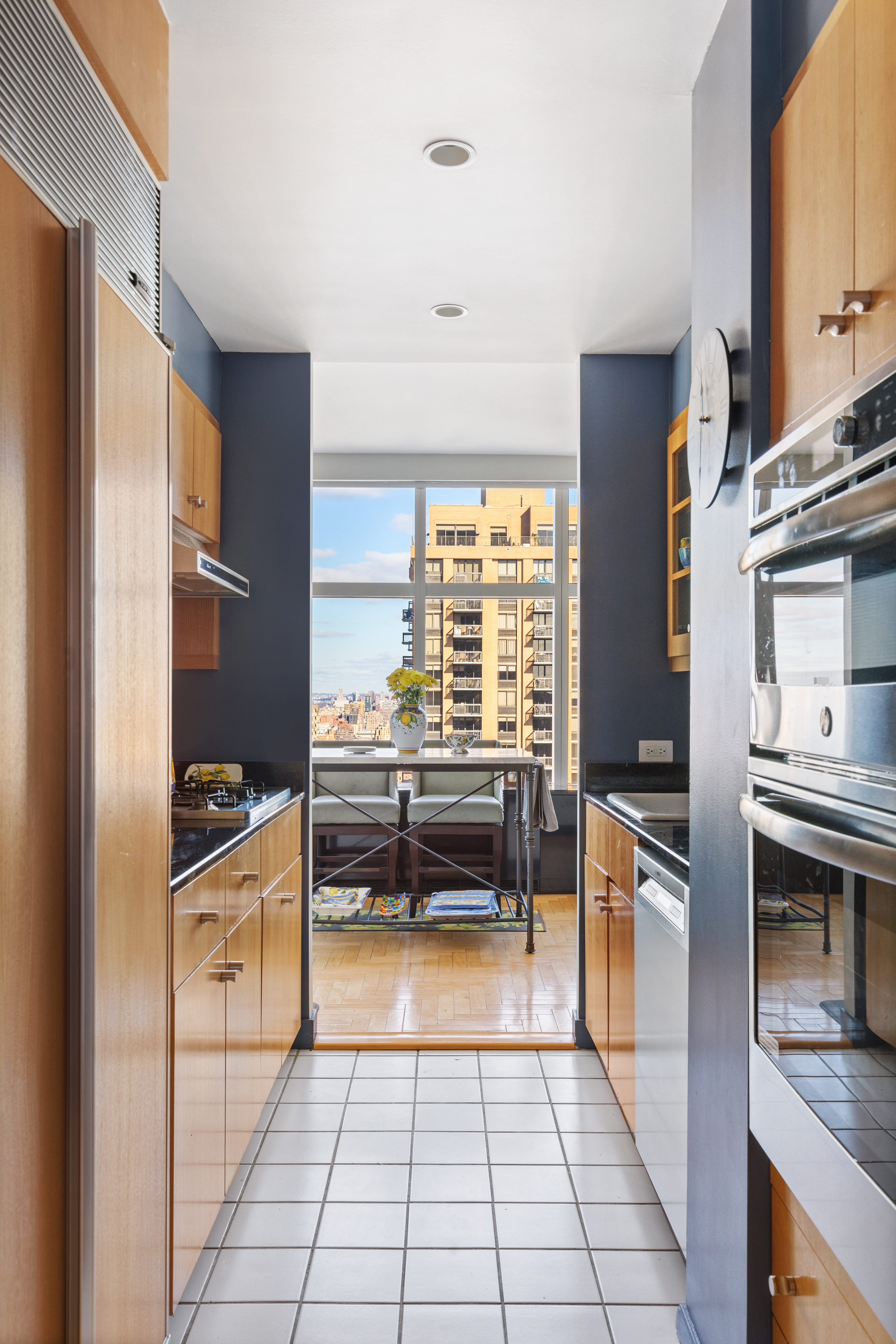 160 West 66th Street, Unit 42AB Manhattan, NY 10023 - Photo 11 of 15 a kitchen with stainless steel appliances granite countertop a refrigerator and a stove top oven
