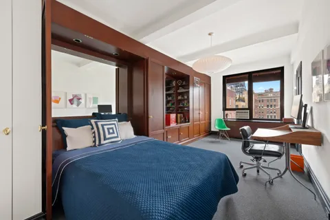 a bedroom with a bed and large windows