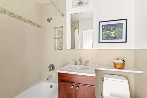 a bathroom with a sink mirror vanity and bathtub
