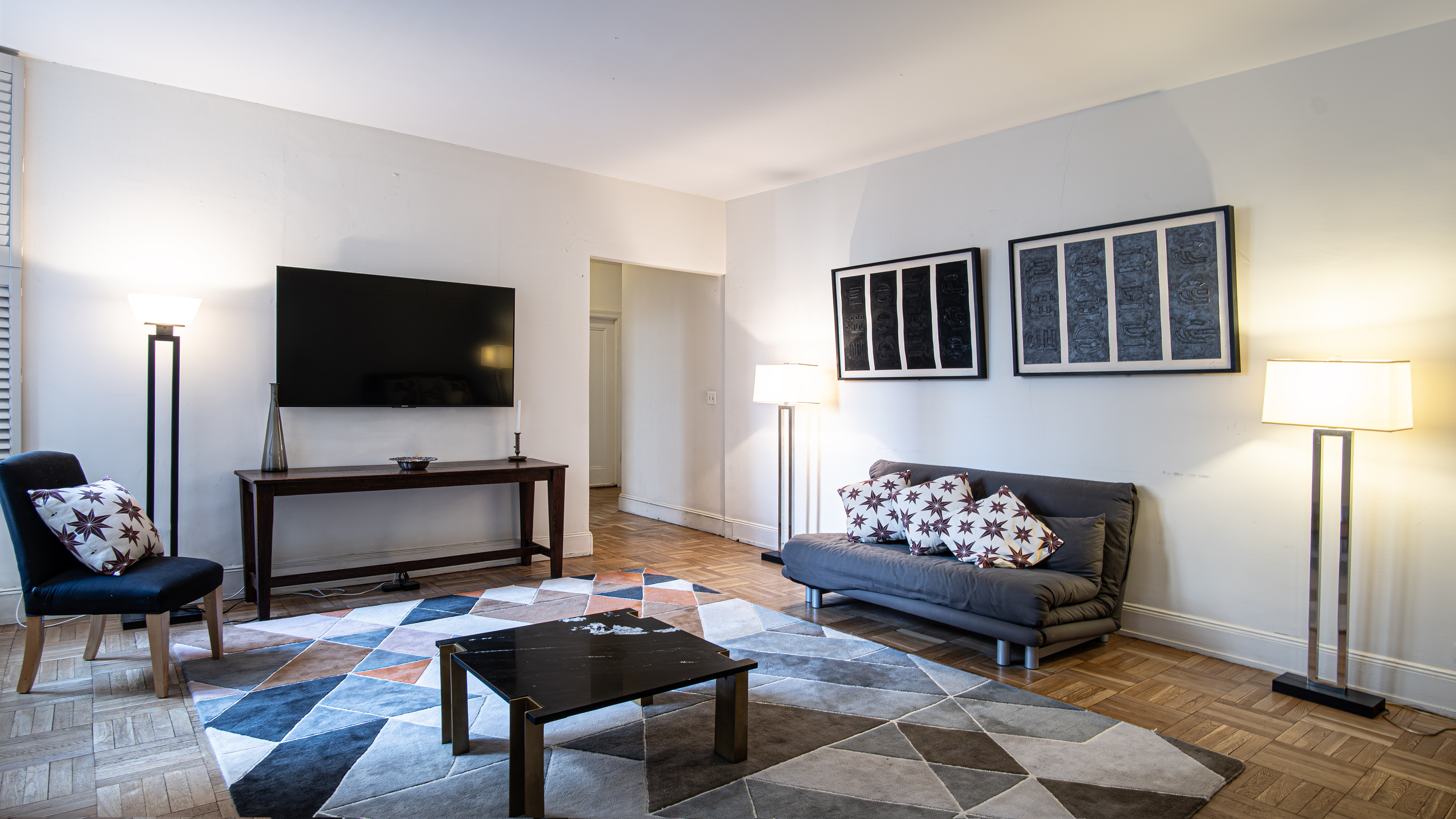 907 5th Avenue, Unit 4F Manhattan, NY 10021 - Photo 5 of 9 a living room with furniture and a flat screen tv