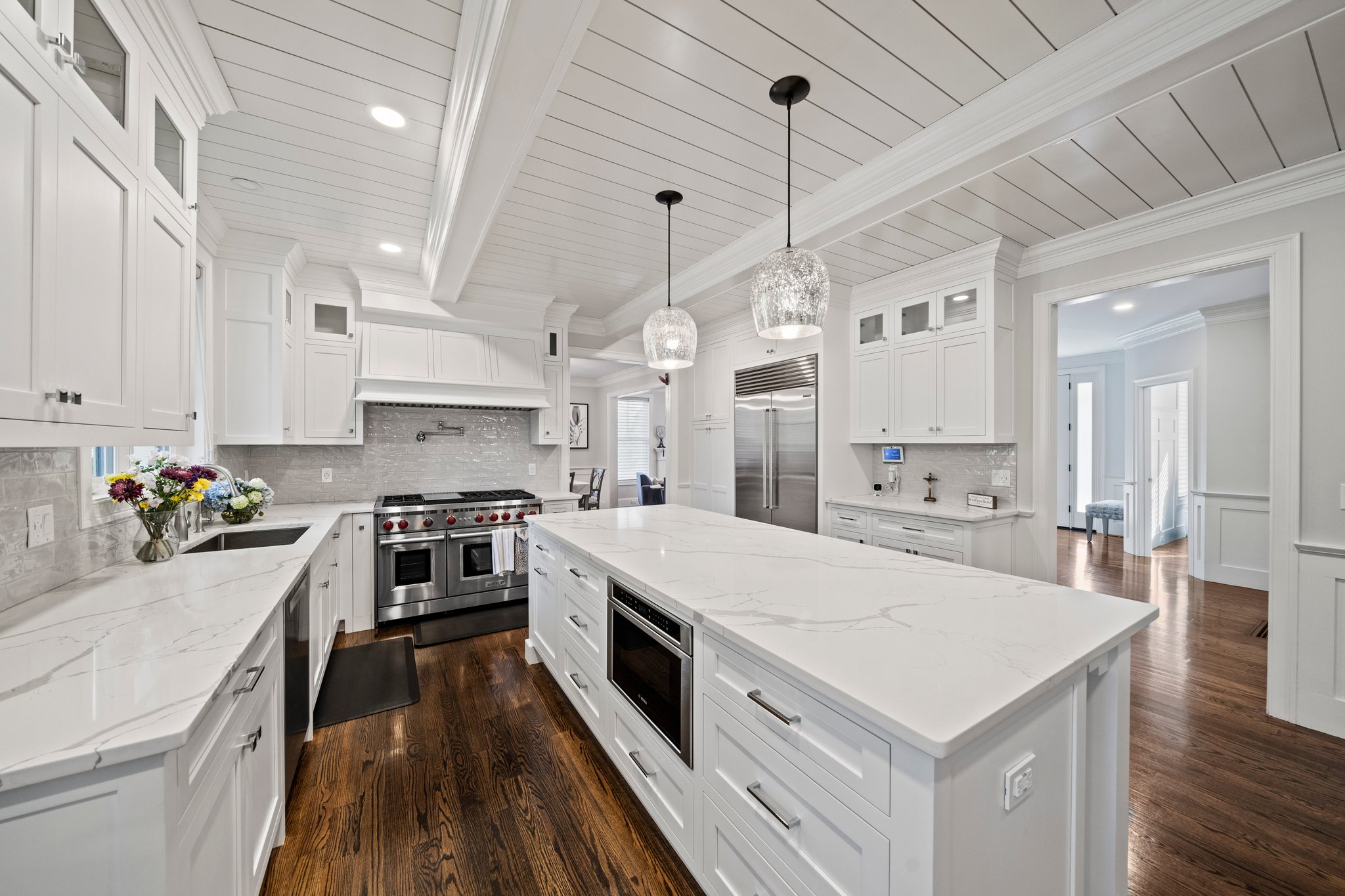 241 Lowell Road Wellesley, MA 02481 - Photo 12 of 85 a large kitchen with kitchen island a stove a sink a refrigerator and white cabinets with wooden floor