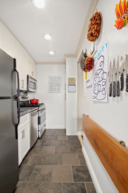 a kitchen with granite countertop a stove and a refrigerator