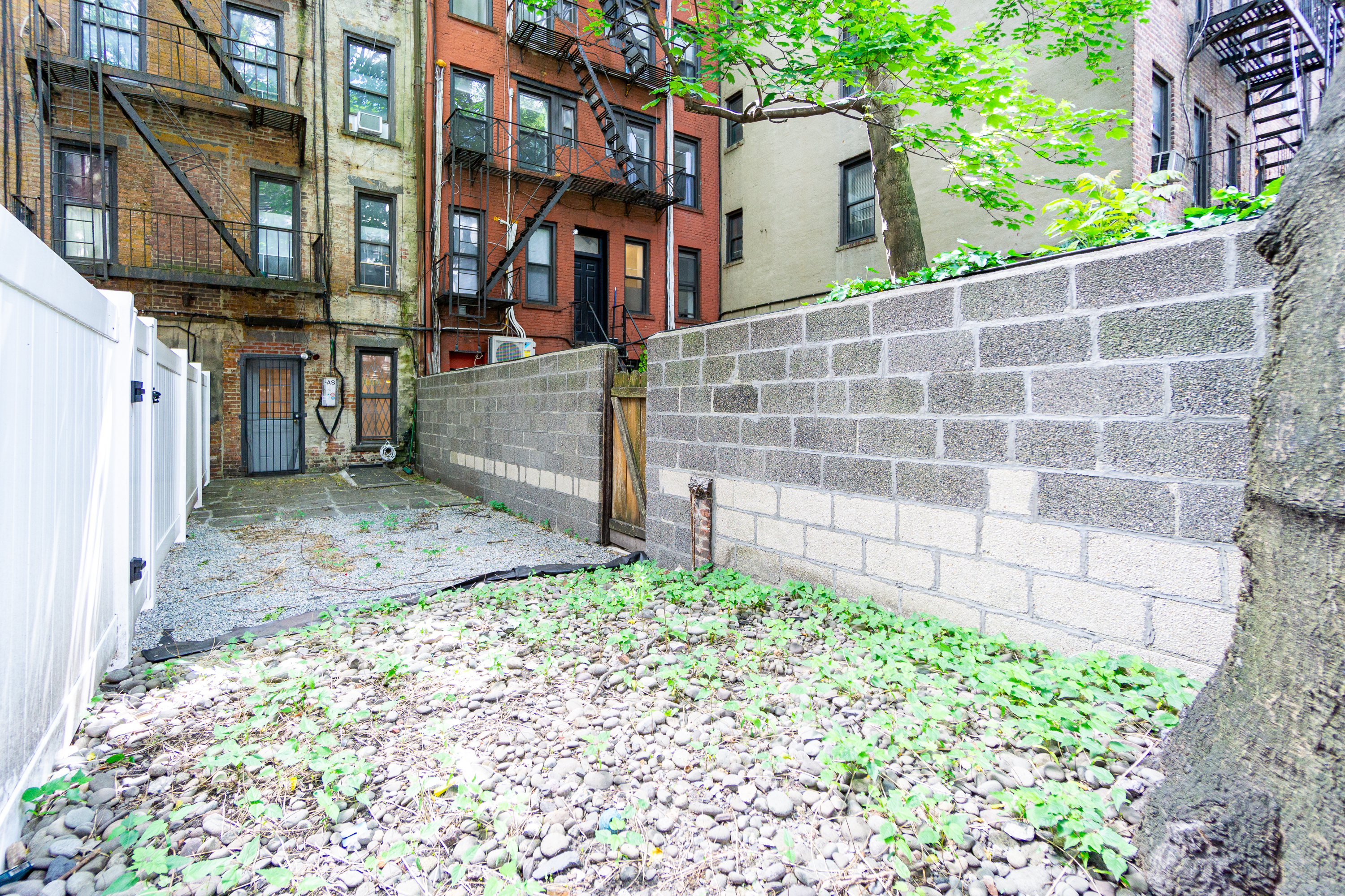 319 East 5th Street, Unit B Manhattan, NY 10003 - Photo 4 of 17 a view of a street with a small yard and wooden fence
