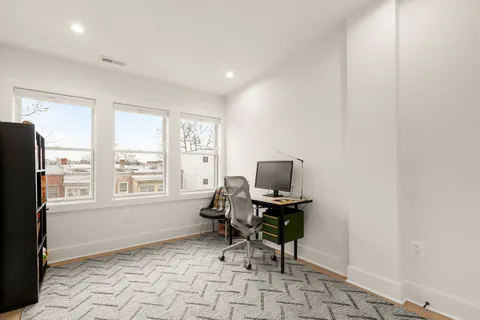 a view of a workspace with furniture and a window