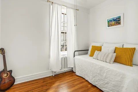 a bedroom with a bed and a wooden floor