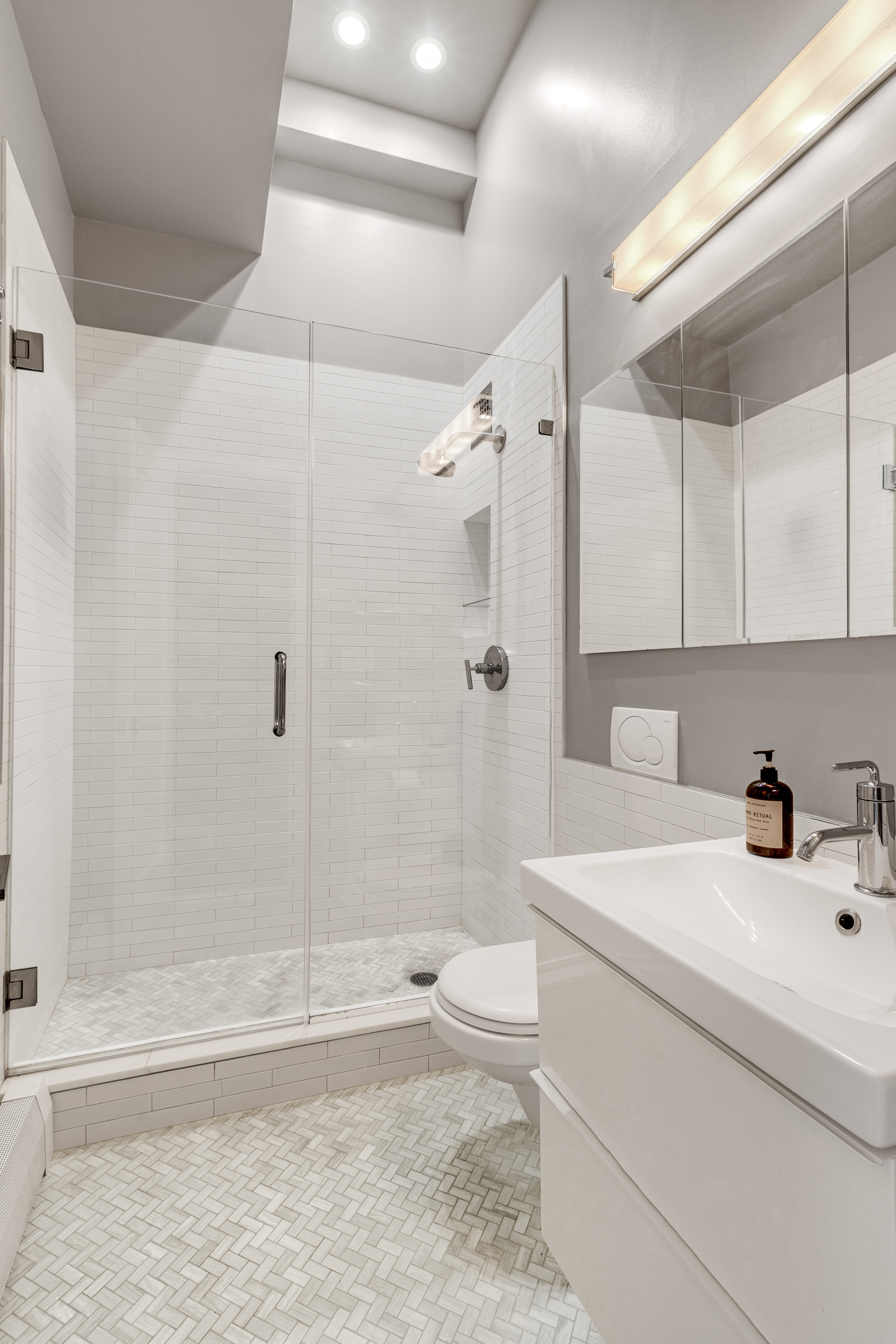 521 West 47th Street, Unit 3A Manhattan, NY 10036 - Photo 12 of 13 a bathroom with a sink a toilet and shower