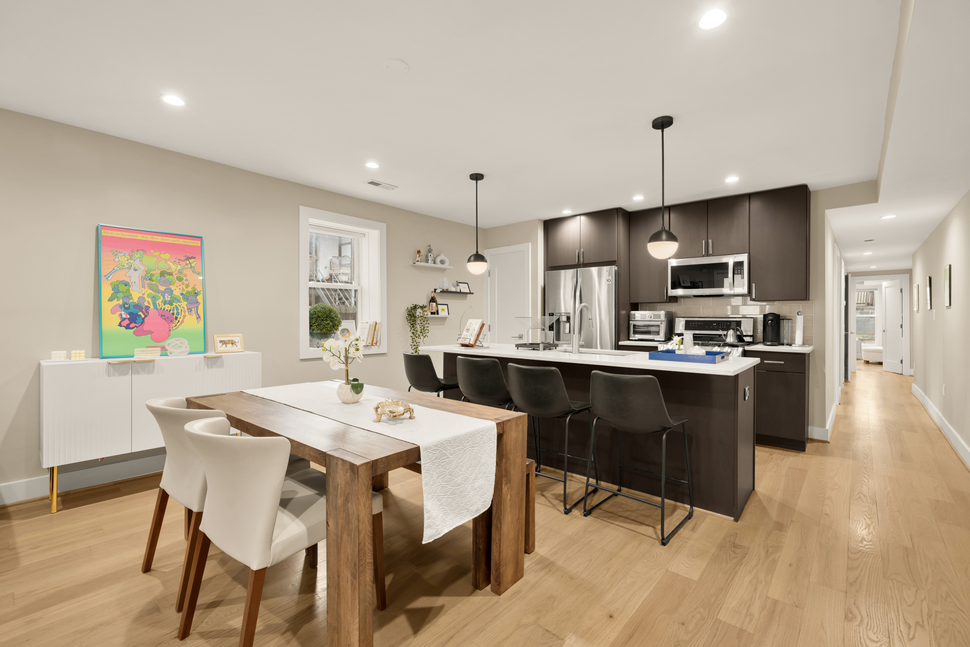 14 T Street Northeast, Unit 1 Washington, DC 20002 - Photo 9 of 39 a kitchen with stainless steel appliances kitchen island granite countertop a sink a stove a dining table and chairs