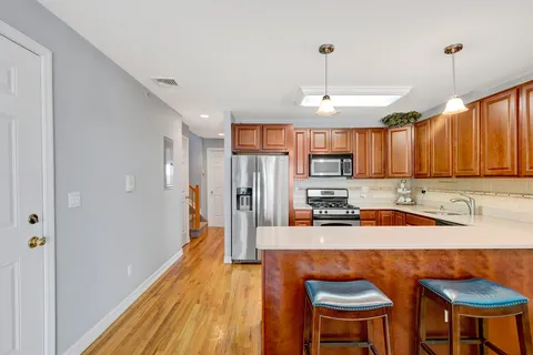a kitchen with stainless steel appliances granite countertop a sink refrigerator and cabinets