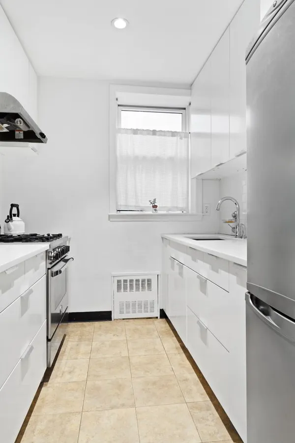 a large white kitchen with a stove a sink dishwasher and a refrigerator
