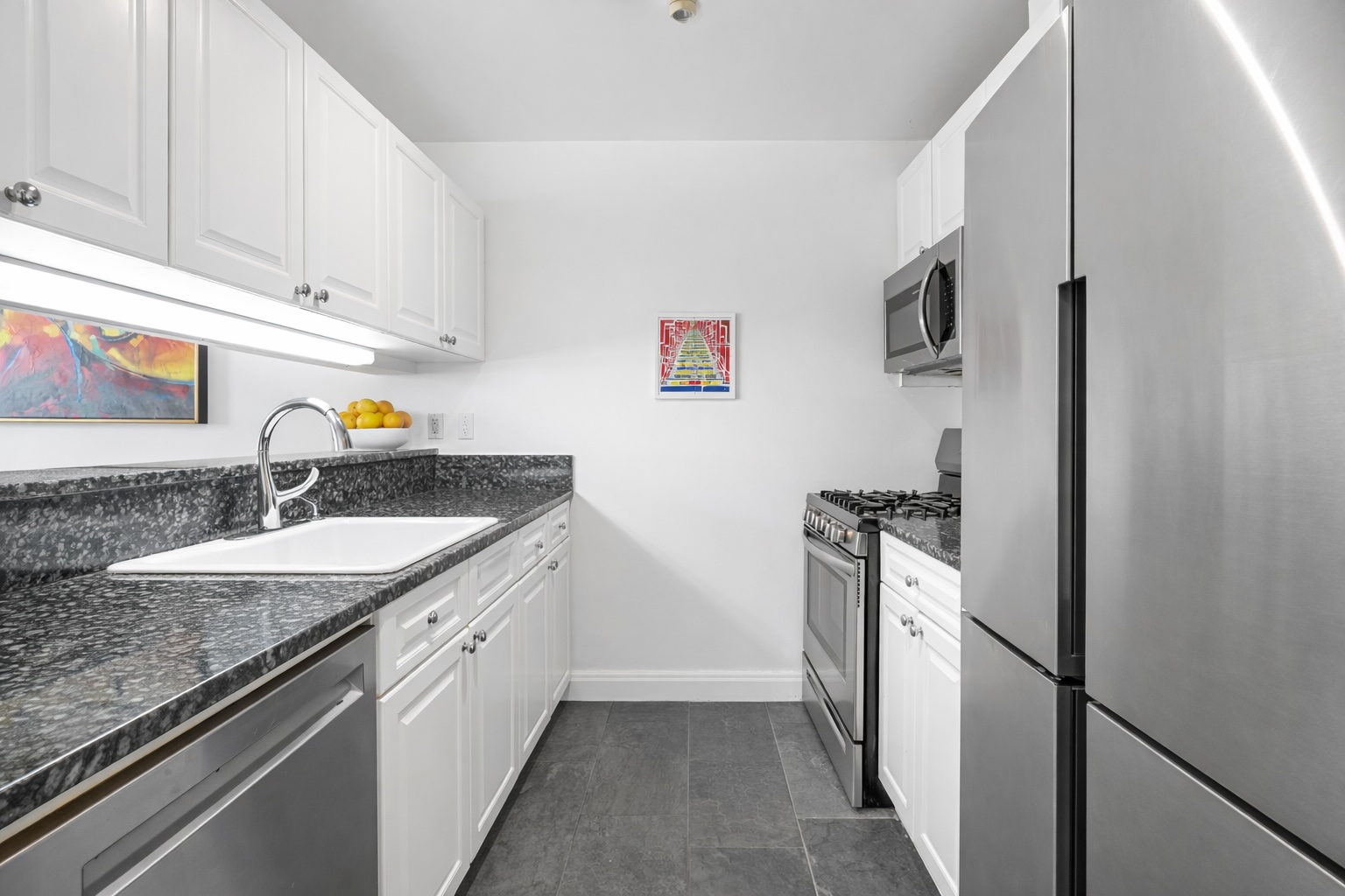 404 East 76th Street, Unit 6K Manhattan, NY 10021 - Photo 3 of 12 a kitchen with stainless steel appliances granite countertop a sink stove and refrigerator