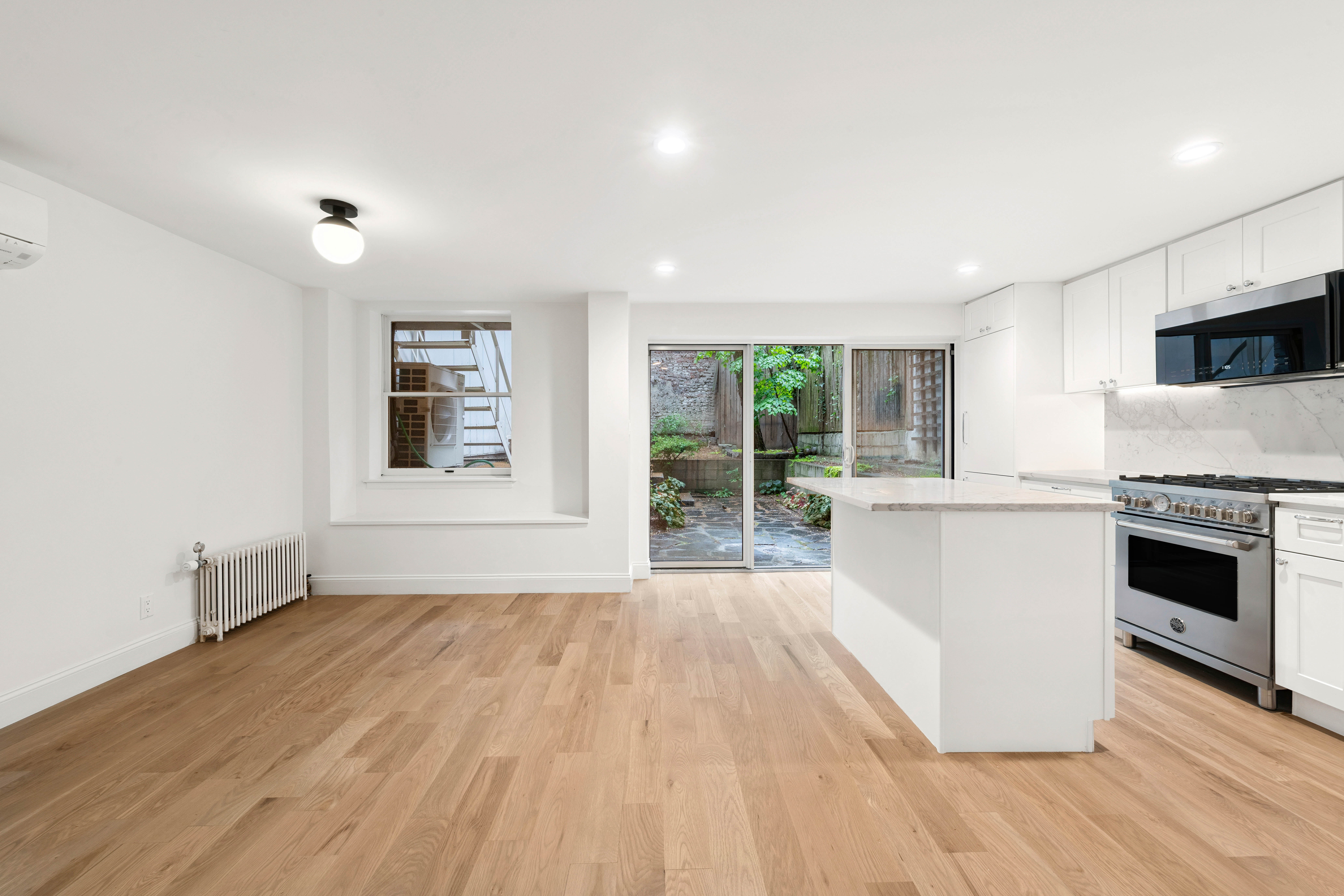 765 Greenwich Street, Unit 1 Manhattan, NY 10014 - Photo 2 of 14 a view of empty room with wooden floor and fireplace