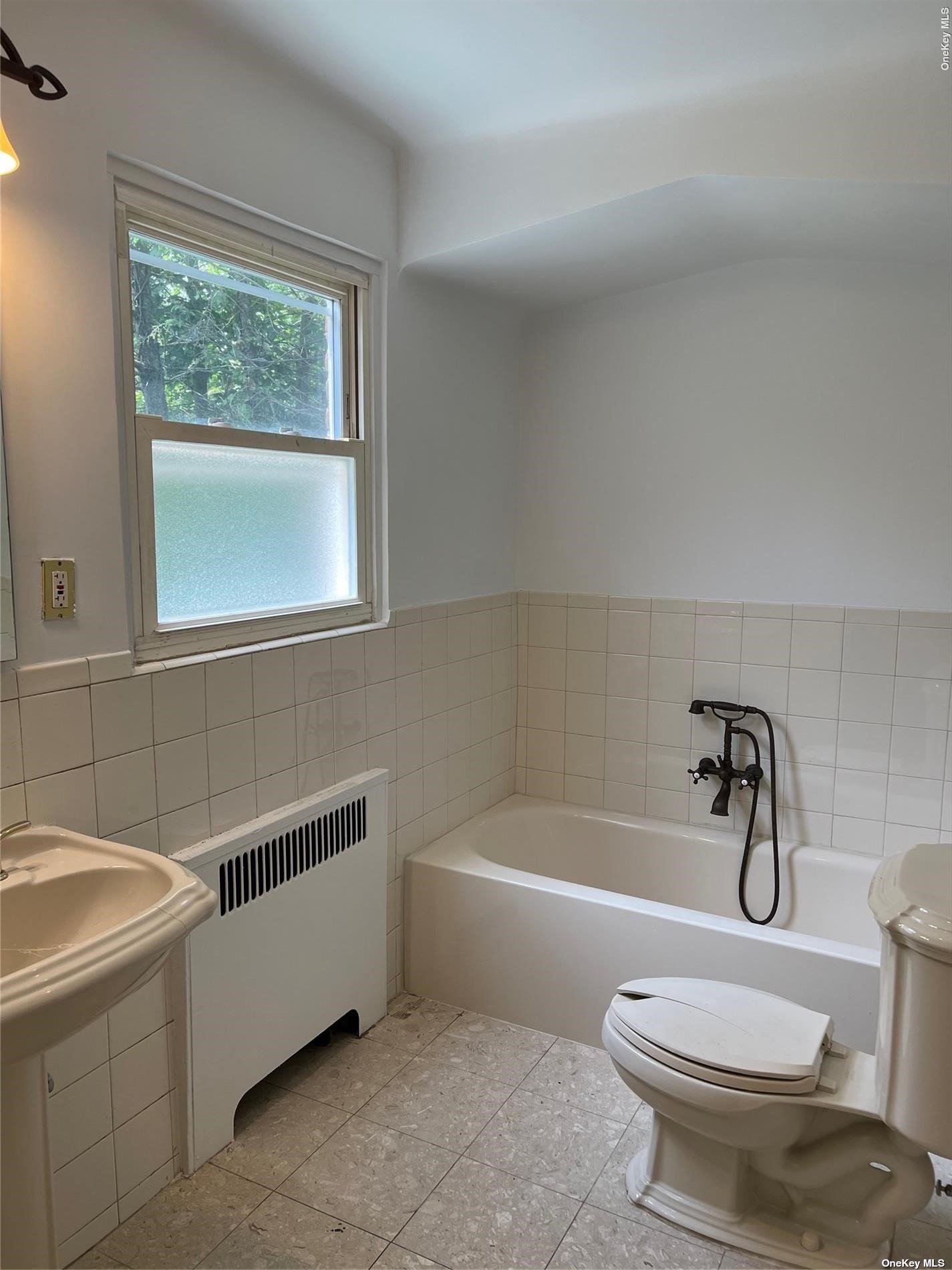 85-23 Edgerton Boulevard Queens, NY 11432 - Photo 17 of 36 a bathroom with a sink a window and a toilet