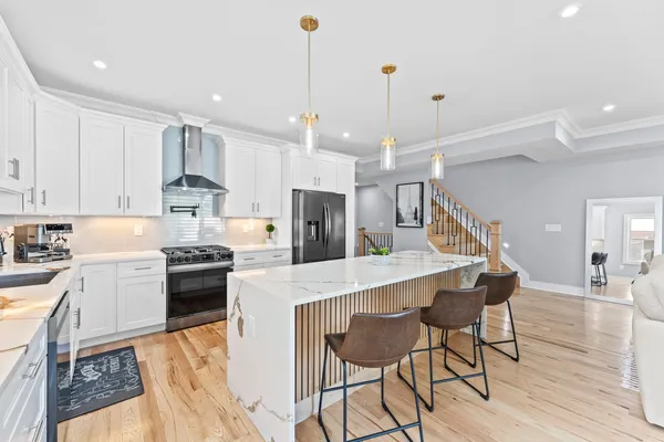 a kitchen with stainless steel appliances kitchen island granite countertop a stove a sink a refrigerator and a counter top space