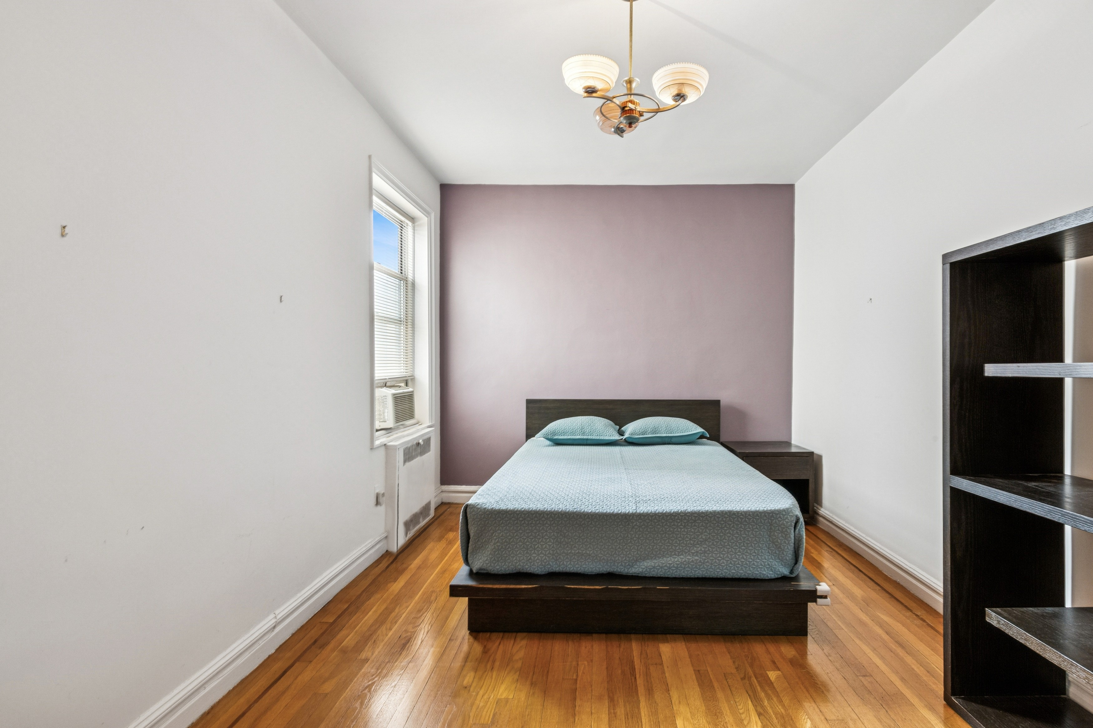 91 Payson Avenue, Unit 4D Manhattan, NY 10034 - Photo 12 of 24 a living room with a bed and a flat screen tv
