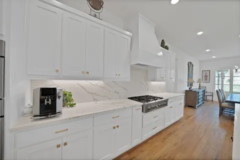 a kitchen with granite countertop a sink a stove and cabinets