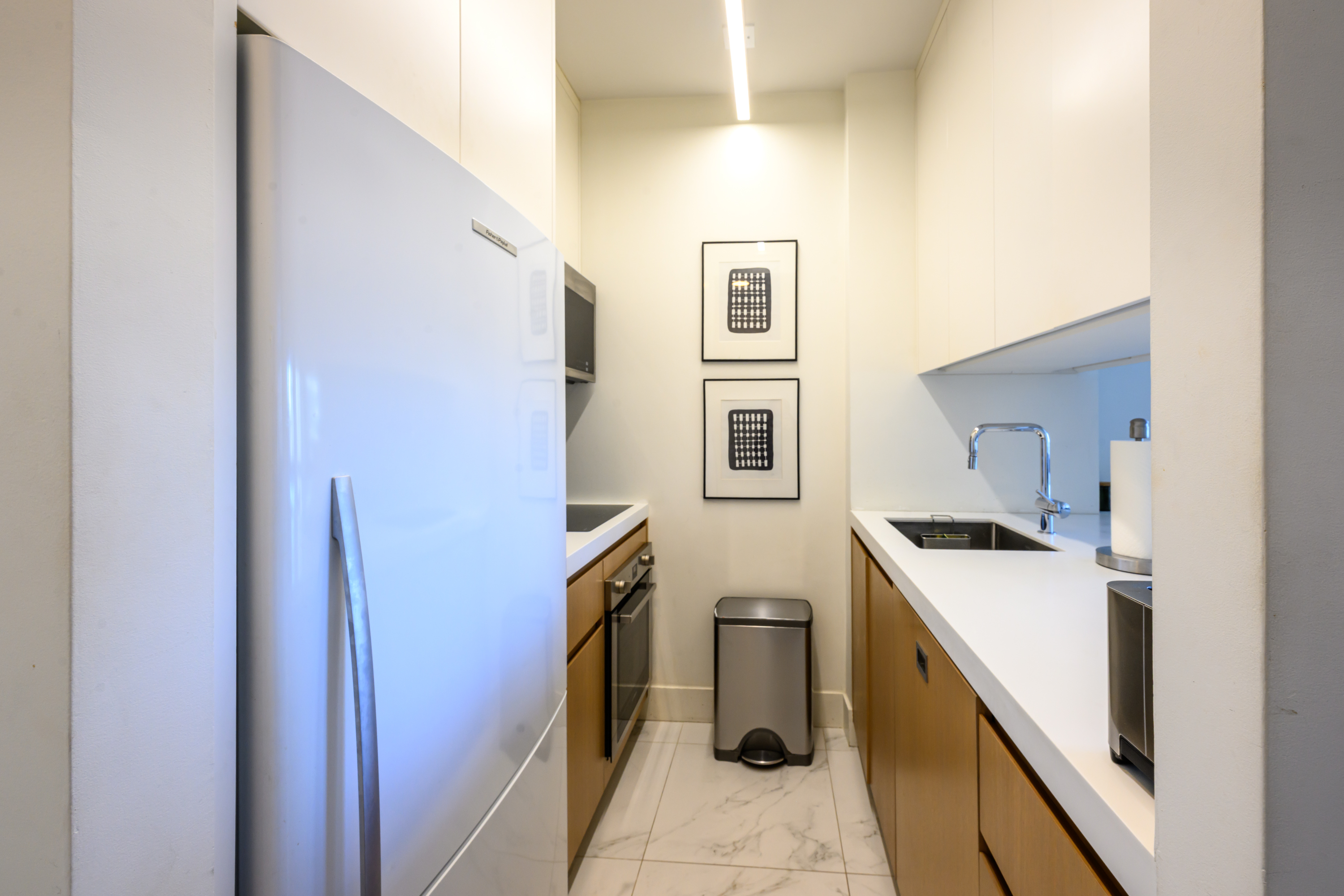 200-210 East 65th Street, Unit 11D Manhattan, NY 10065 - Photo 6 of 15 a kitchen with a sink a stove and refrigerator