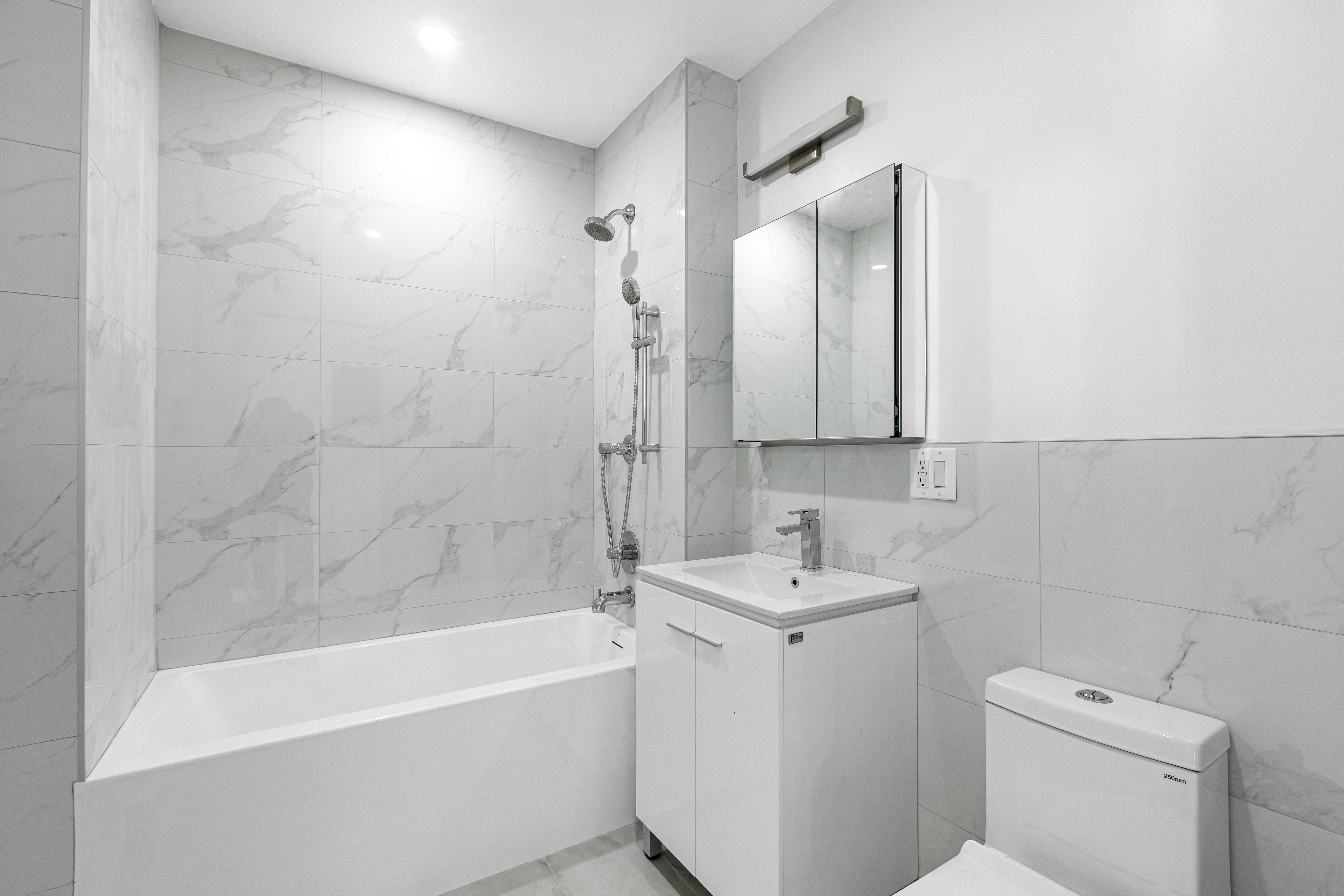 1463 New York Avenue, Unit 5B Brooklyn, NY 11210 - Photo 5 of 8 a bathroom with a sink a toilet and shower