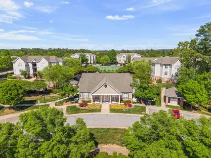 an aerial view of a house with big yard and large trees