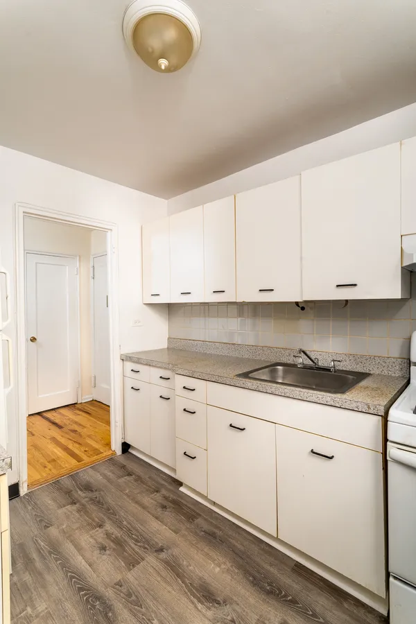a kitchen with granite countertop a sink a stove and cabinets