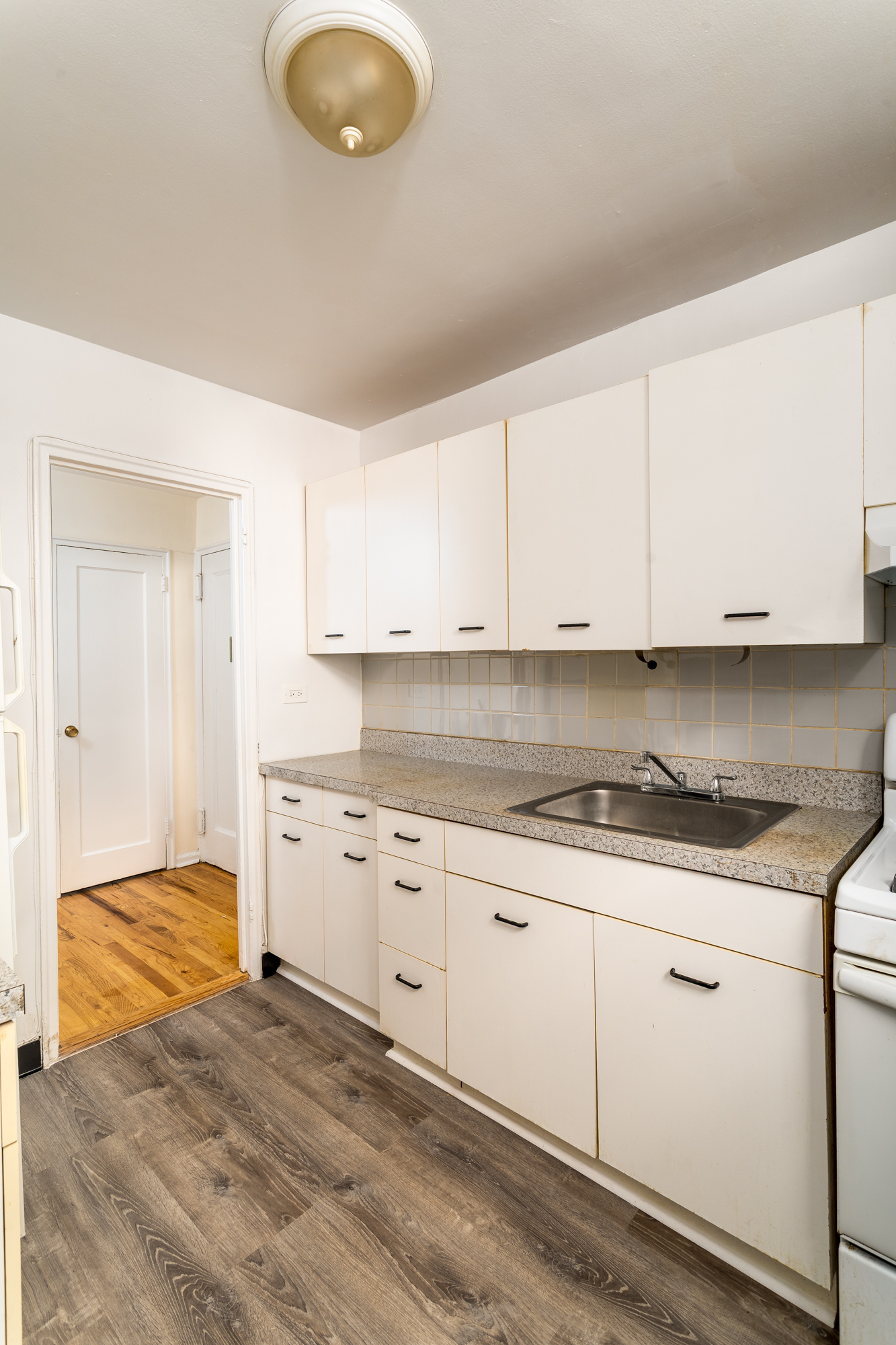5610 Netherland Avenue, Unit 1G Bronx, NY 10471 - Photo 6 of 14 a kitchen with granite countertop a sink a stove and cabinets