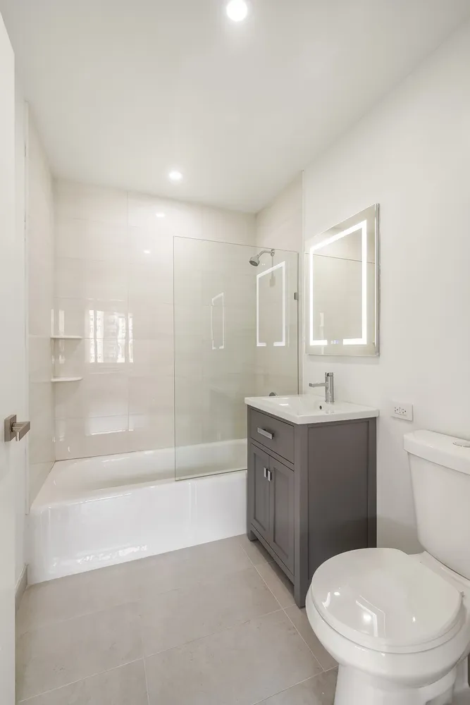 a bathroom with a bathtub shower sink vanity and toilet