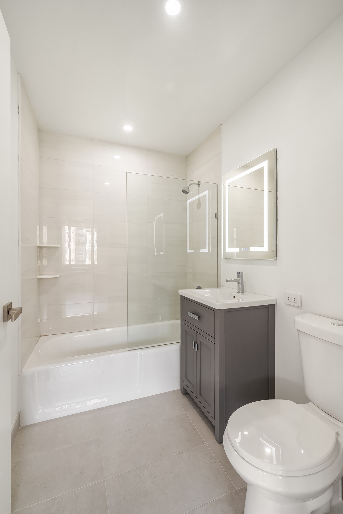 35 West 33rd Street, Unit 4B Manhattan, NY 10001 - Photo 5 of 17 a bathroom with a bathtub shower sink vanity and toilet