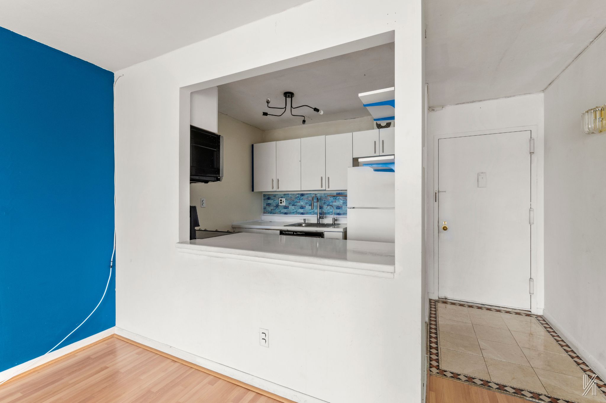 25-40 Shore Boulevard, Unit 4R Queens, NY 11102 - Photo 4 of 11 a kitchen with a refrigerator and white cabinets