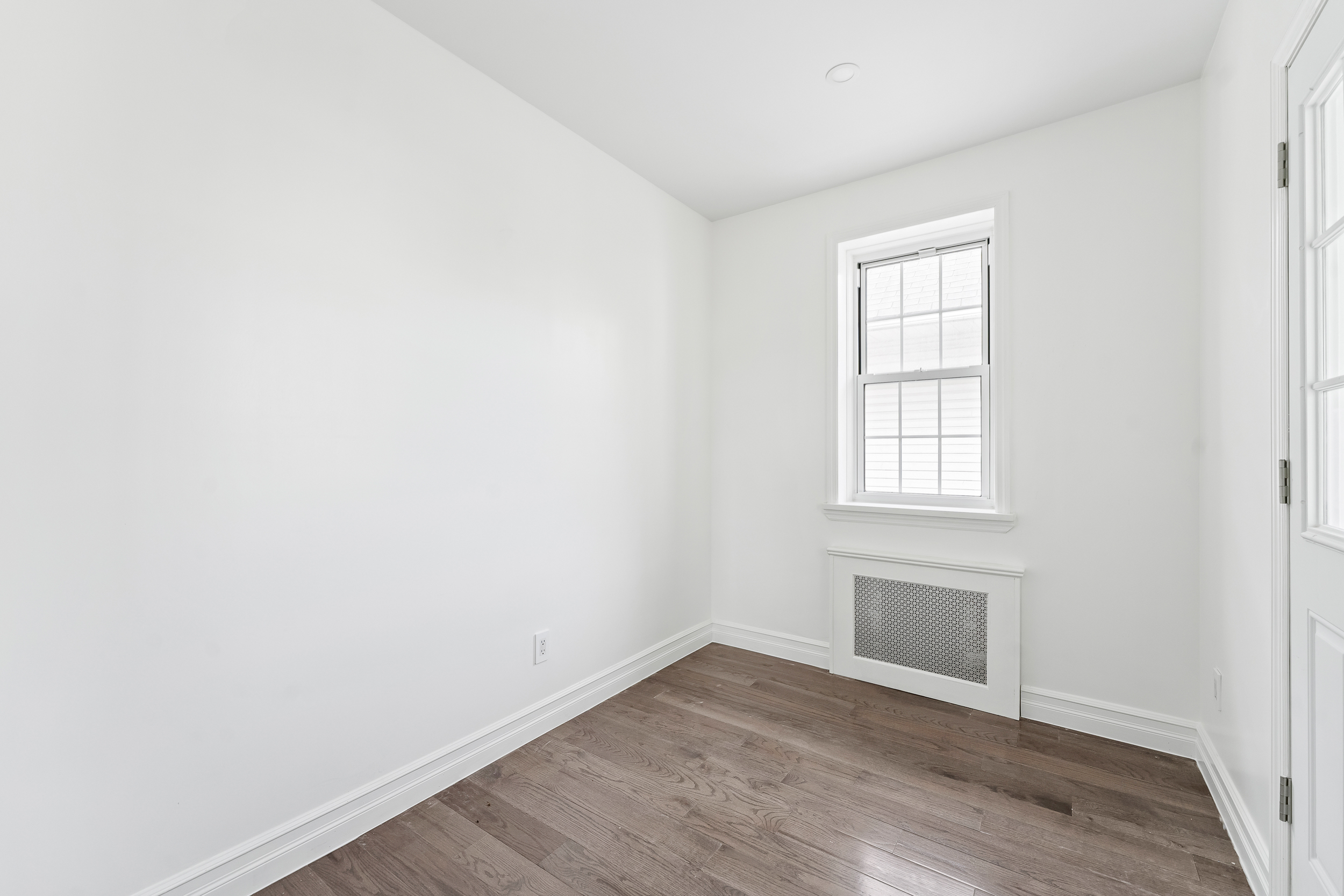 65 Bay 23rd Street, Unit 2 Brooklyn, NY 11214 - Photo 12 of 16 an empty room with wooden floor and windows