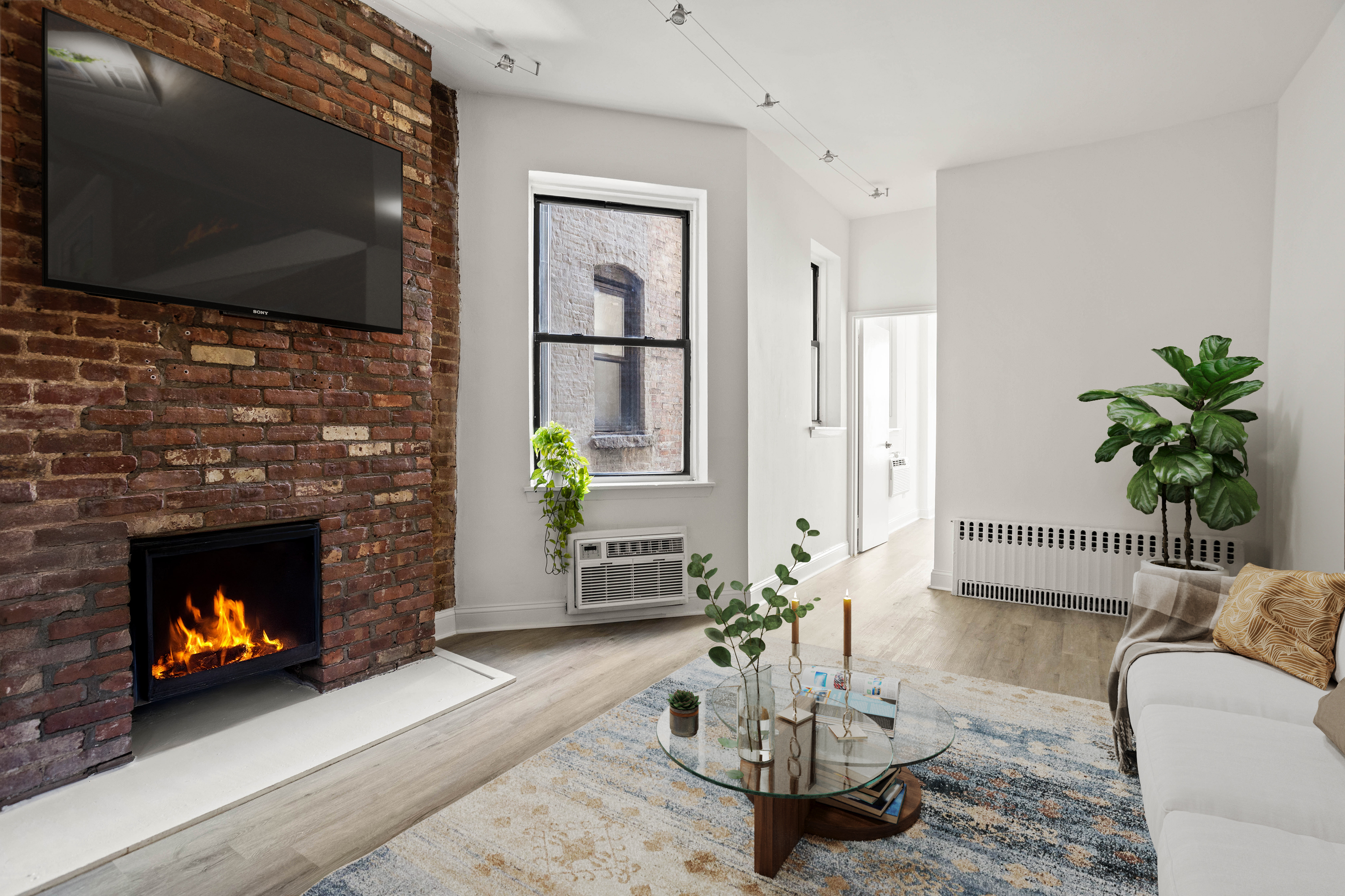 519 East 87th Street, Unit 2C Manhattan, NY 10128 - Photo 3 of 6 a living room with furniture a flat screen tv and a fireplace