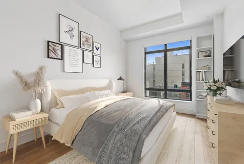 a bedroom with a bed and a large mirror
