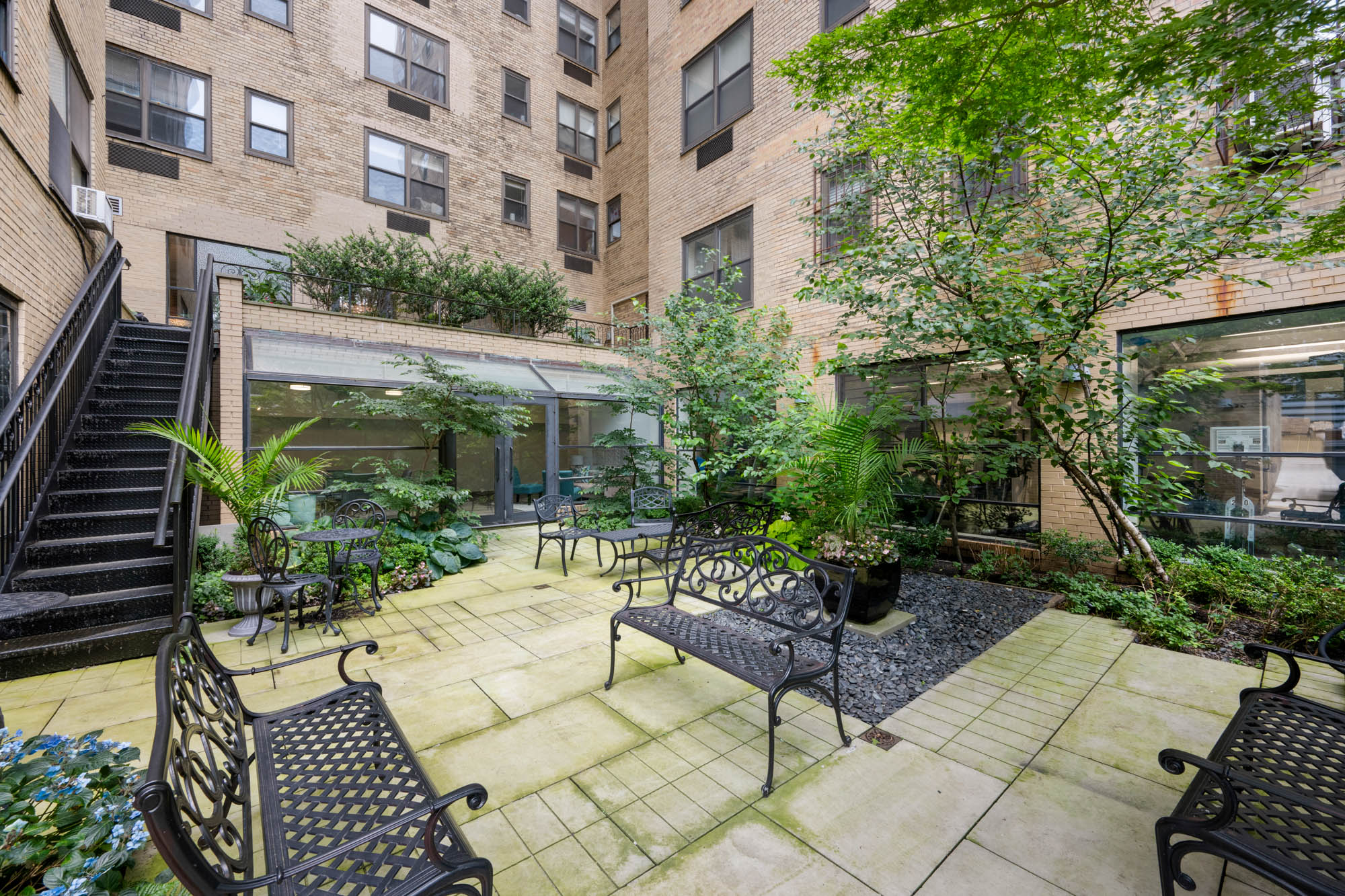 230 Riverside Drive, Unit 8D Manhattan, NY 10025 - Photo 14 of 19 a view of a patio with couches table and chairs and potted plants