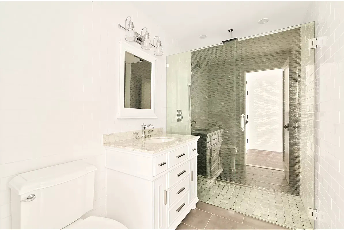 894 Greene Avenue Brooklyn, NY 11221 - Photo 7 of 11 a bathroom with a sink a toilet and shower