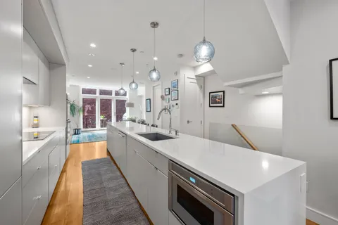 a large kitchen with kitchen island a stove a sink a center island and couches