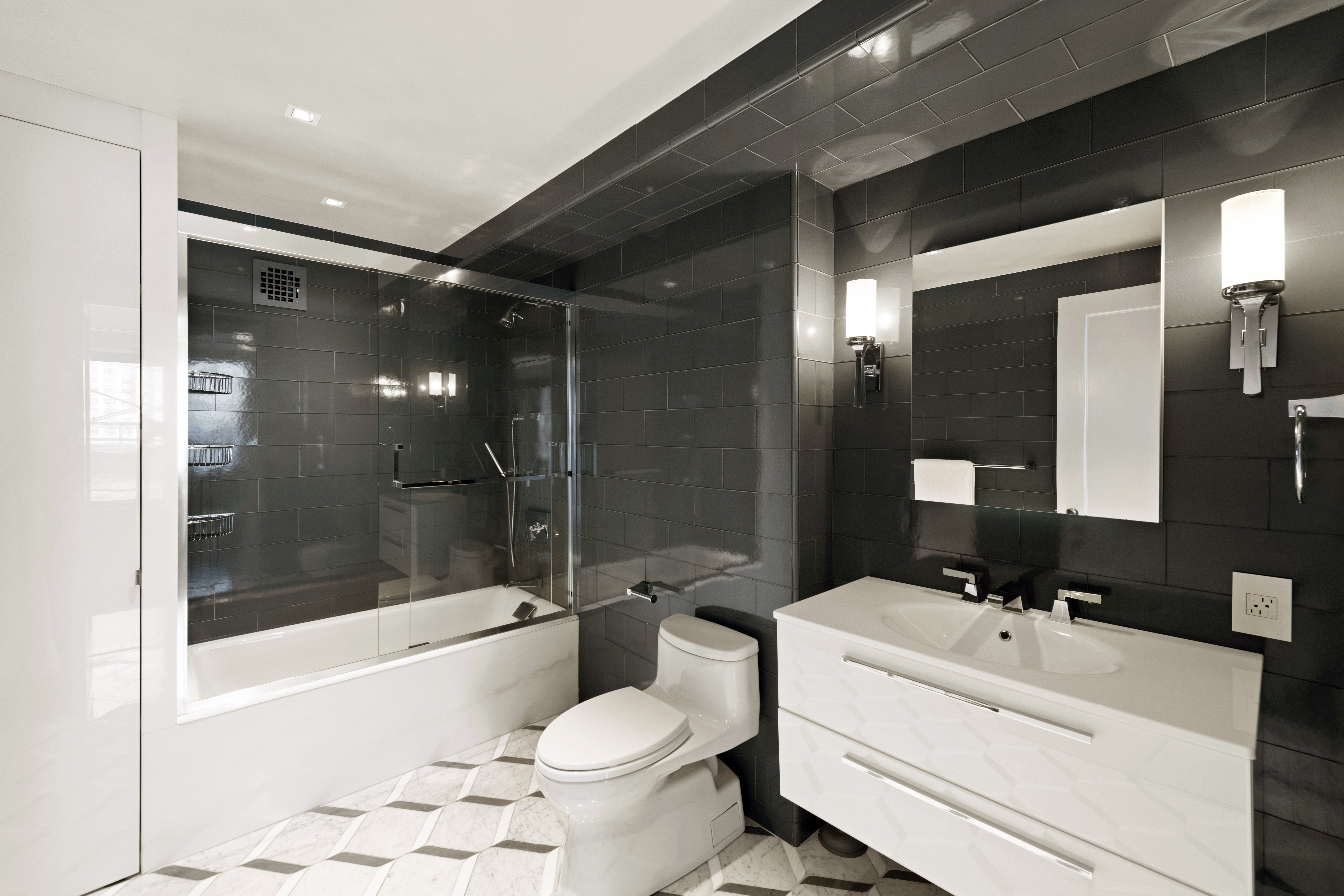 180 East End Avenue, Unit 15E Manhattan, NY 10128 - Photo 18 of 31 a bathroom with a bathtub shower sink mirror and toilet