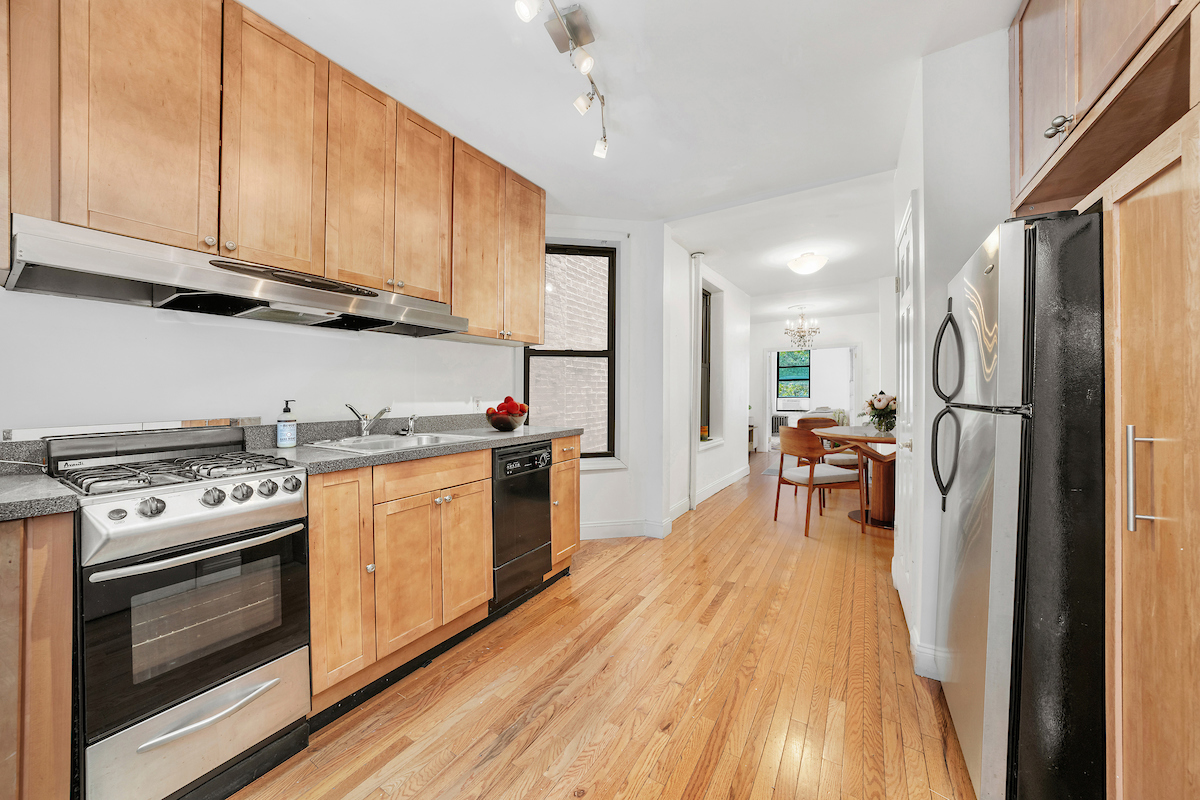 112 East 98th Street, Unit 4W Manhattan, NY 10029 - Photo 1 of 6 a kitchen with stainless steel appliances a stove a sink dishwasher a refrigerator white cabinets with wooden floor