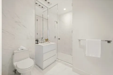 a white toilet sitting next to a bathroom sink