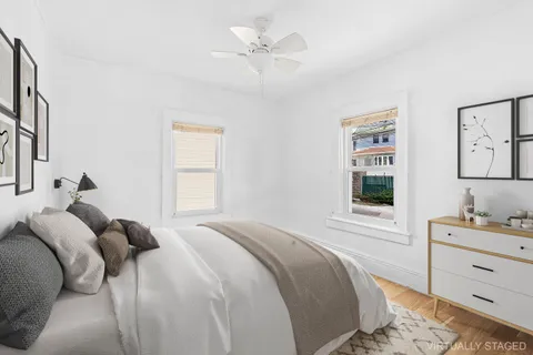 a bedroom with a bed and a window with a dresser