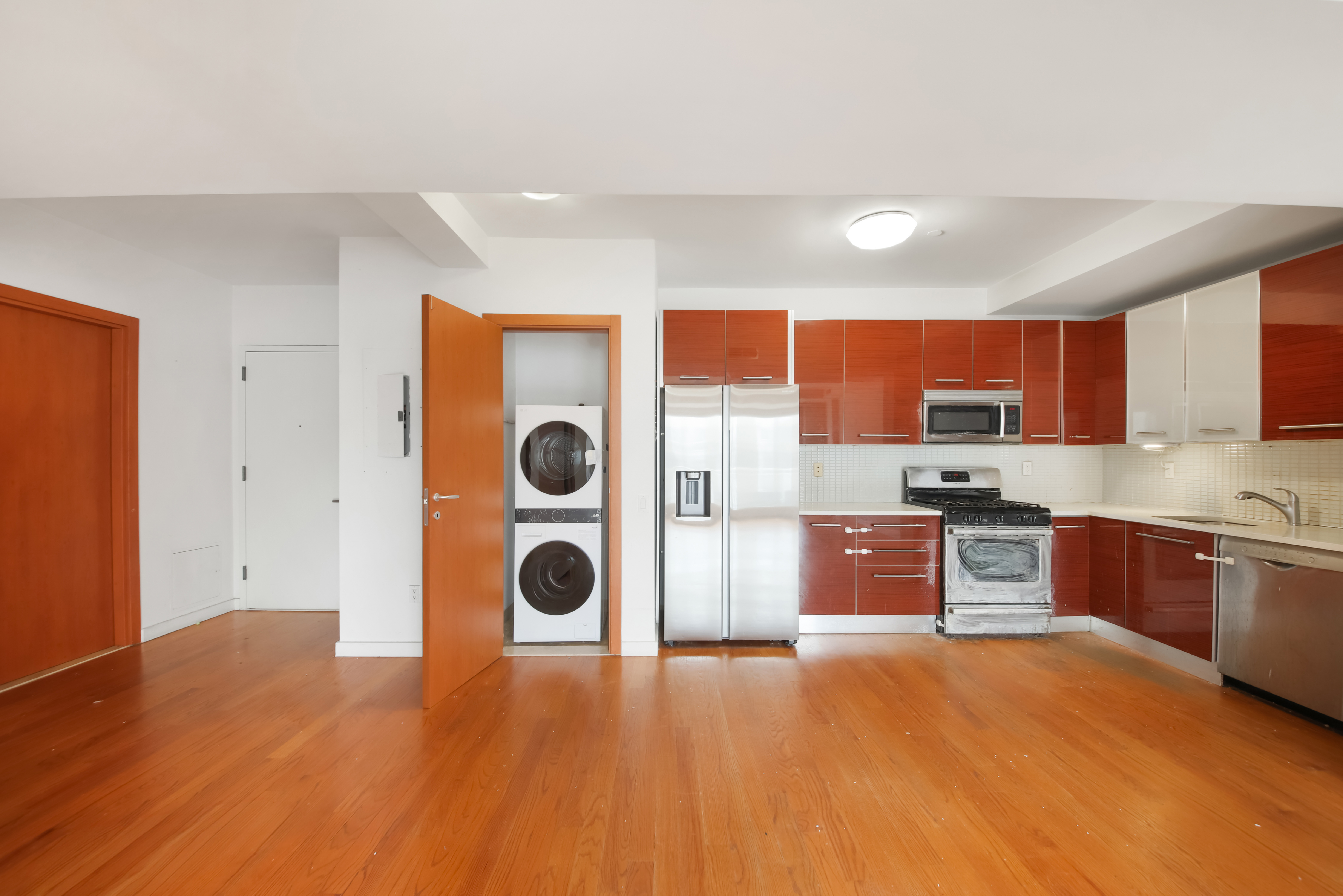 3112 Emmons Avenue, Unit 107 Brooklyn, NY 11235 - Photo 3 of 14 a kitchen with stainless steel appliances granite countertop a refrigerator a sink dishwasher and wooden cabinets with wooden floor