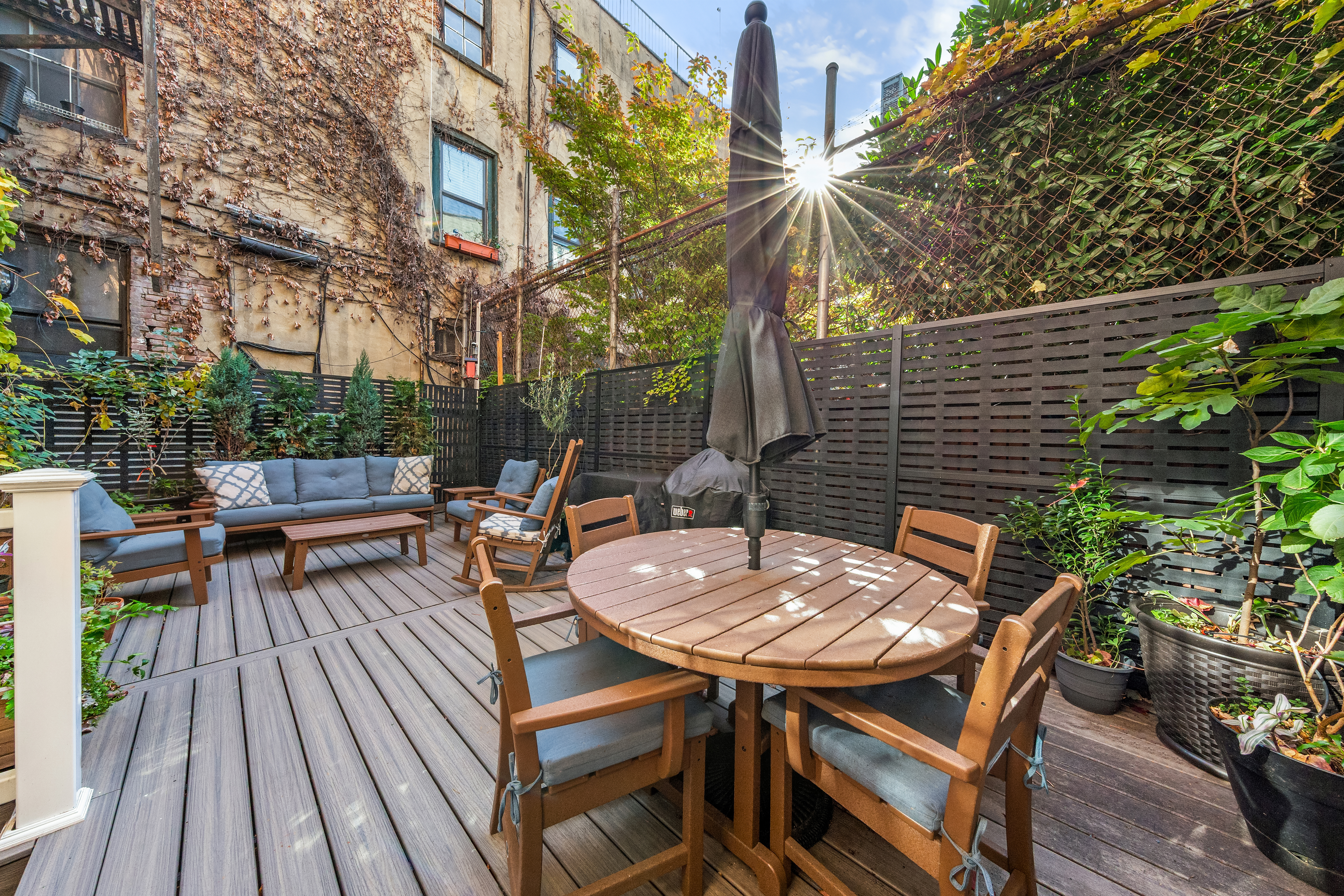 406 West 47th Street, Unit 2D Manhattan, NY 10036 - Photo 5 of 7 a backyard of a house with barbeque oven table and chairs