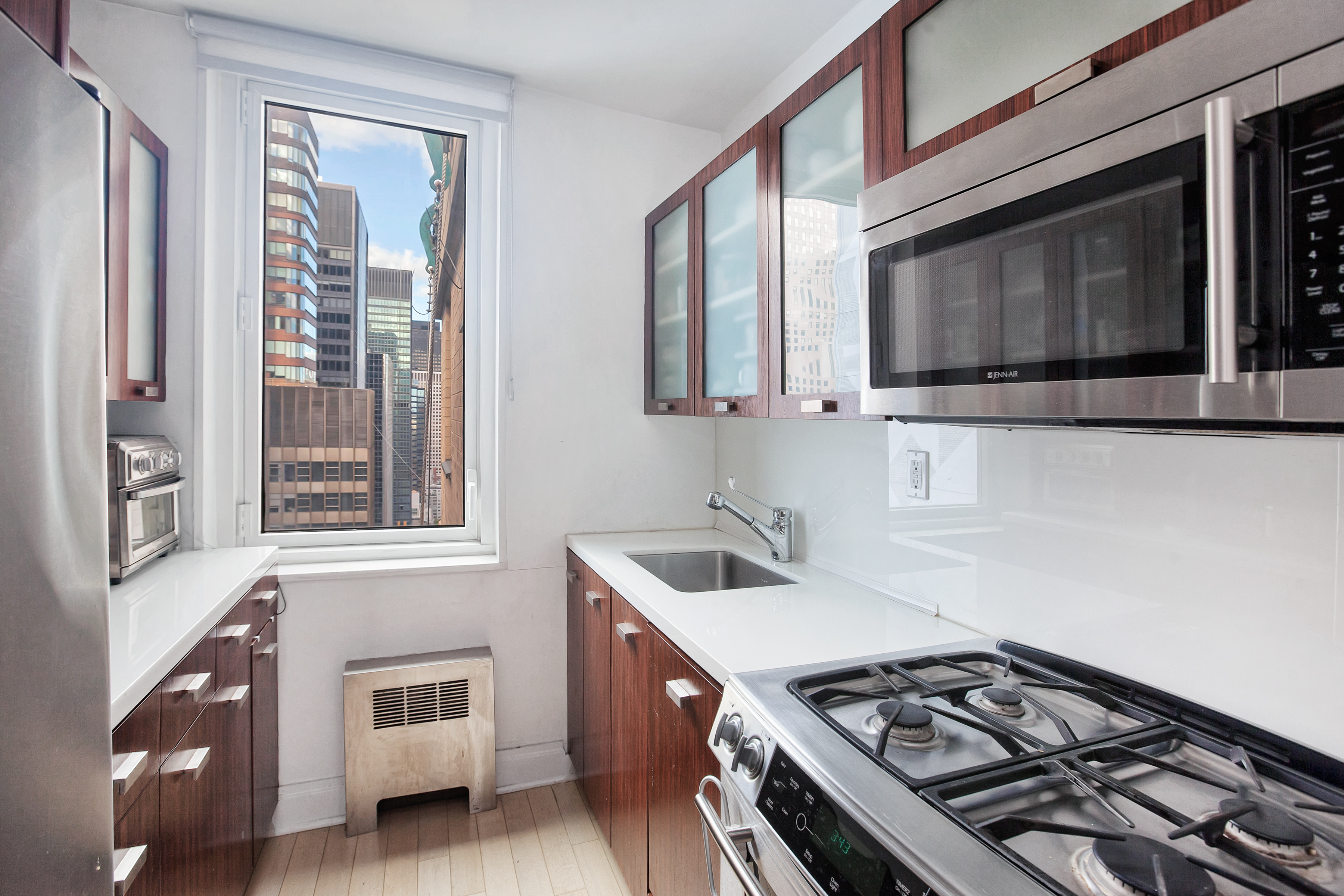 212 East 47th Street, Unit PHB Manhattan, NY 10017 - Photo 3 of 6 a kitchen with stainless steel appliances granite countertop a stove and a microwave