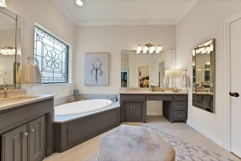 a spacious bathroom with a double vanity sink mirror and bathtub