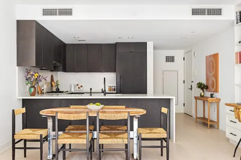 a kitchen with a table chairs and a refrigerator