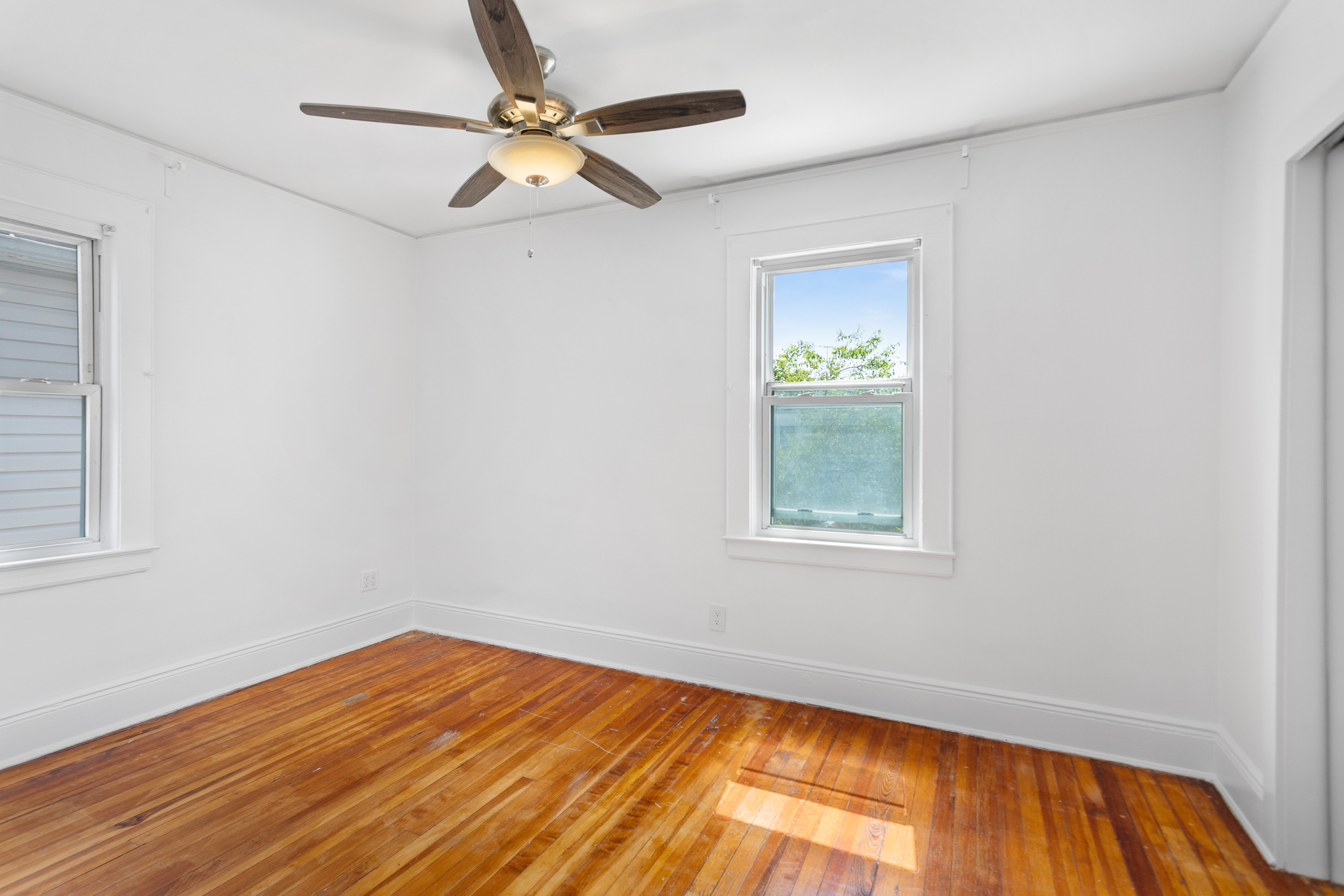 91-22 92nd Street Queens, NY 11421 - Photo 10 of 27 a view of empty room with wooden floor and fan