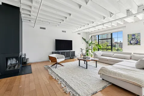 a living room with furniture a flat screen tv and a table