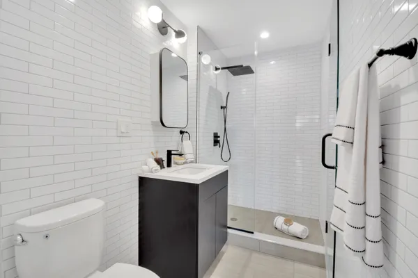 a bathroom with a sink a toilet and shower